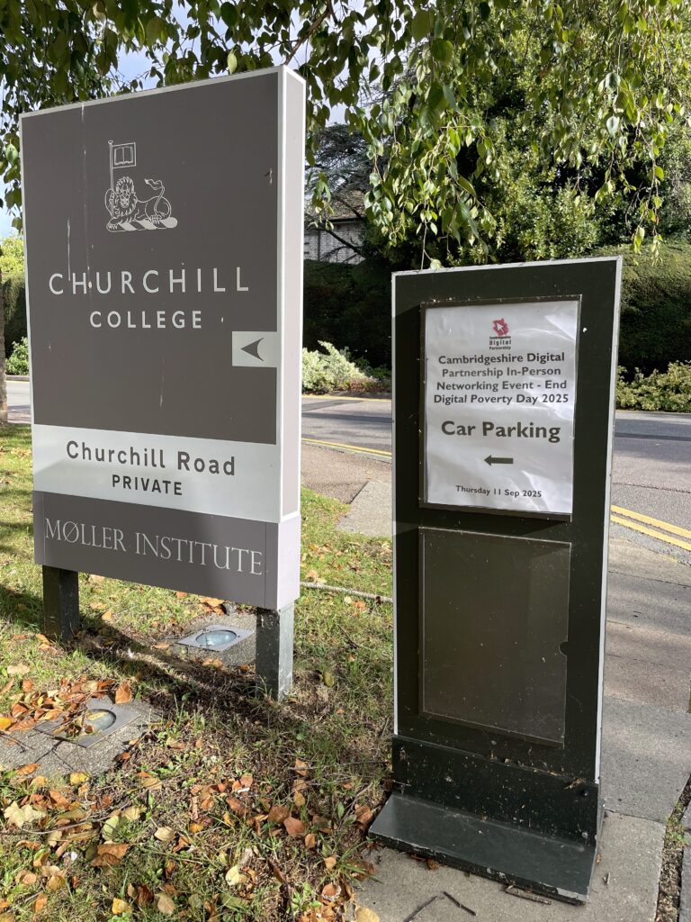 Churchill College sign outside in the ground with a CDP car parking poster.