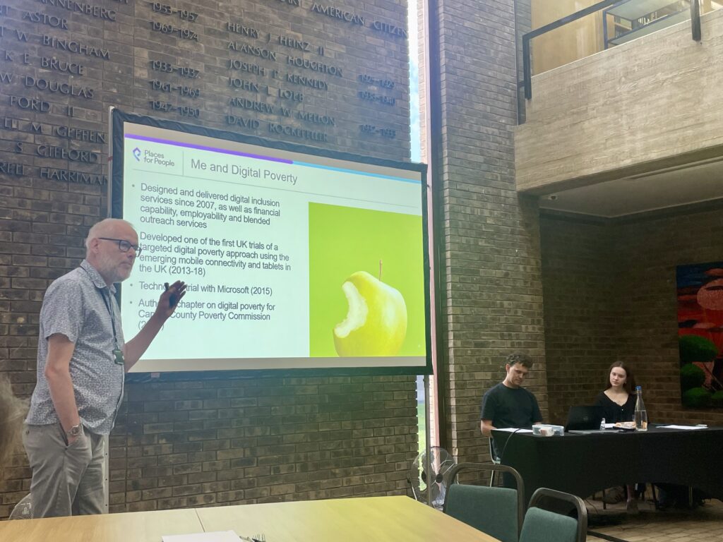 One person stood in front of a big screen showing a Powerpoint presentation.